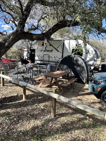 The Perkins' r-pod trailer and picnic table at a wooded campsite